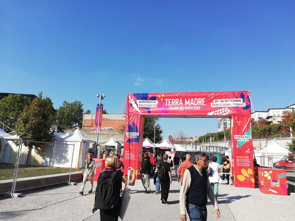 Посетители пристигнуваат низ означениот влез на Terra Madre Salone del Gusto во Торино во 2022 година.