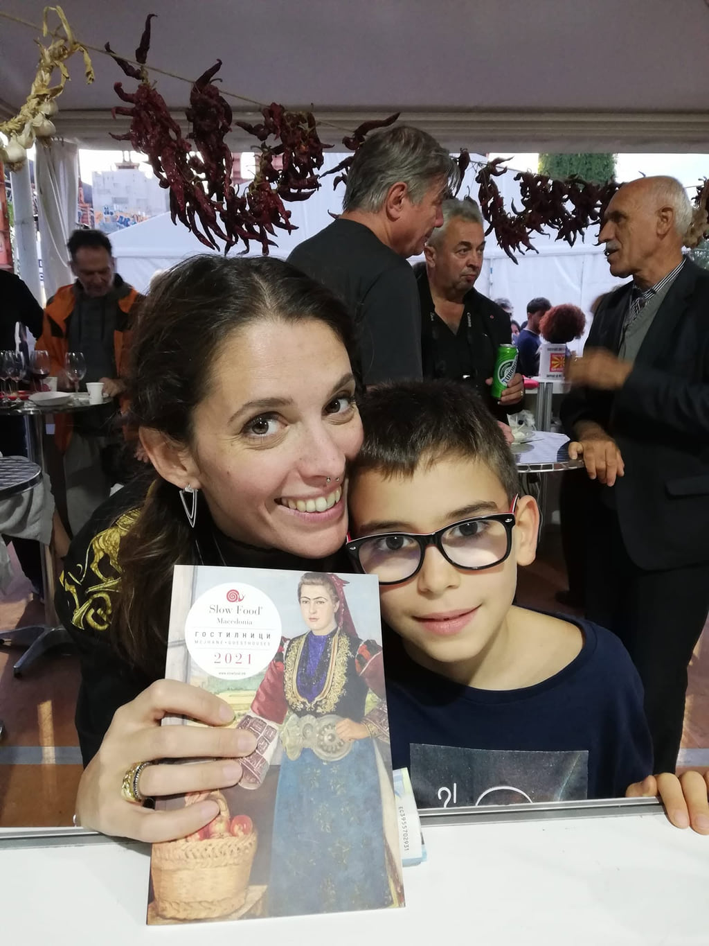 Жена и момче држат илустриран материјал на настан на Slow Food Macedonia.